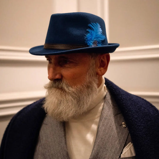 modello maturo con cappello trilby classico primario nesti in lana merinos royal dettaglio profilo con barba bianca e interior design elegante