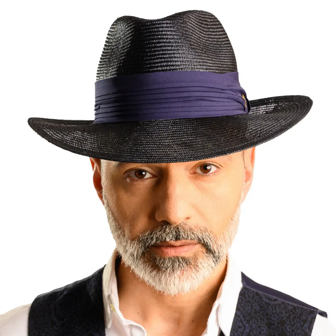 primo piano frontale di uomo con barba che indossa un cappello fedora elegante in parasisol color blu fatto da cappelleria primario nesti