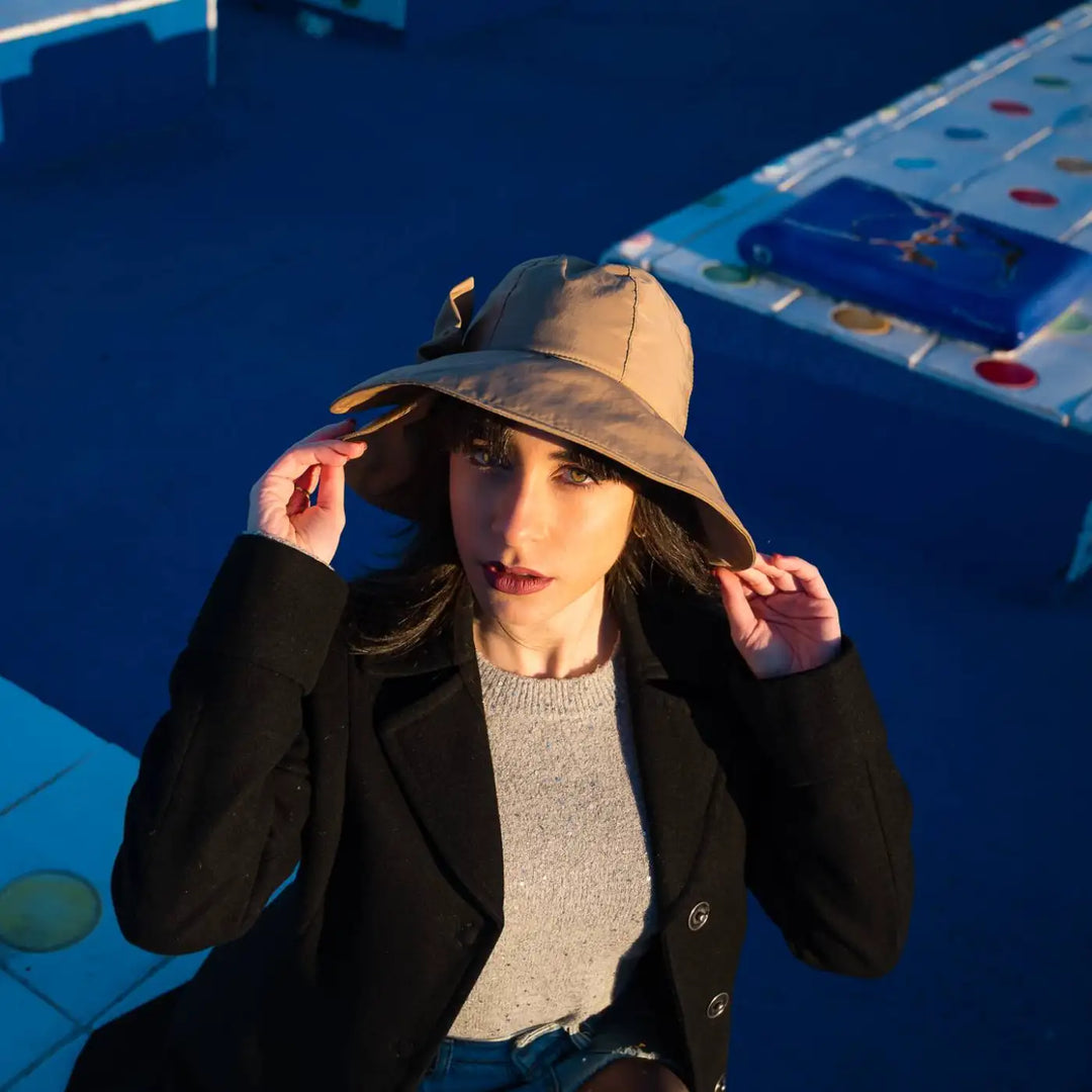 bucket impermeabile con fiocco primario nesti cammello sotto luce naturale taglio fotografico dinamico massima espressione dello stile contemporaneo