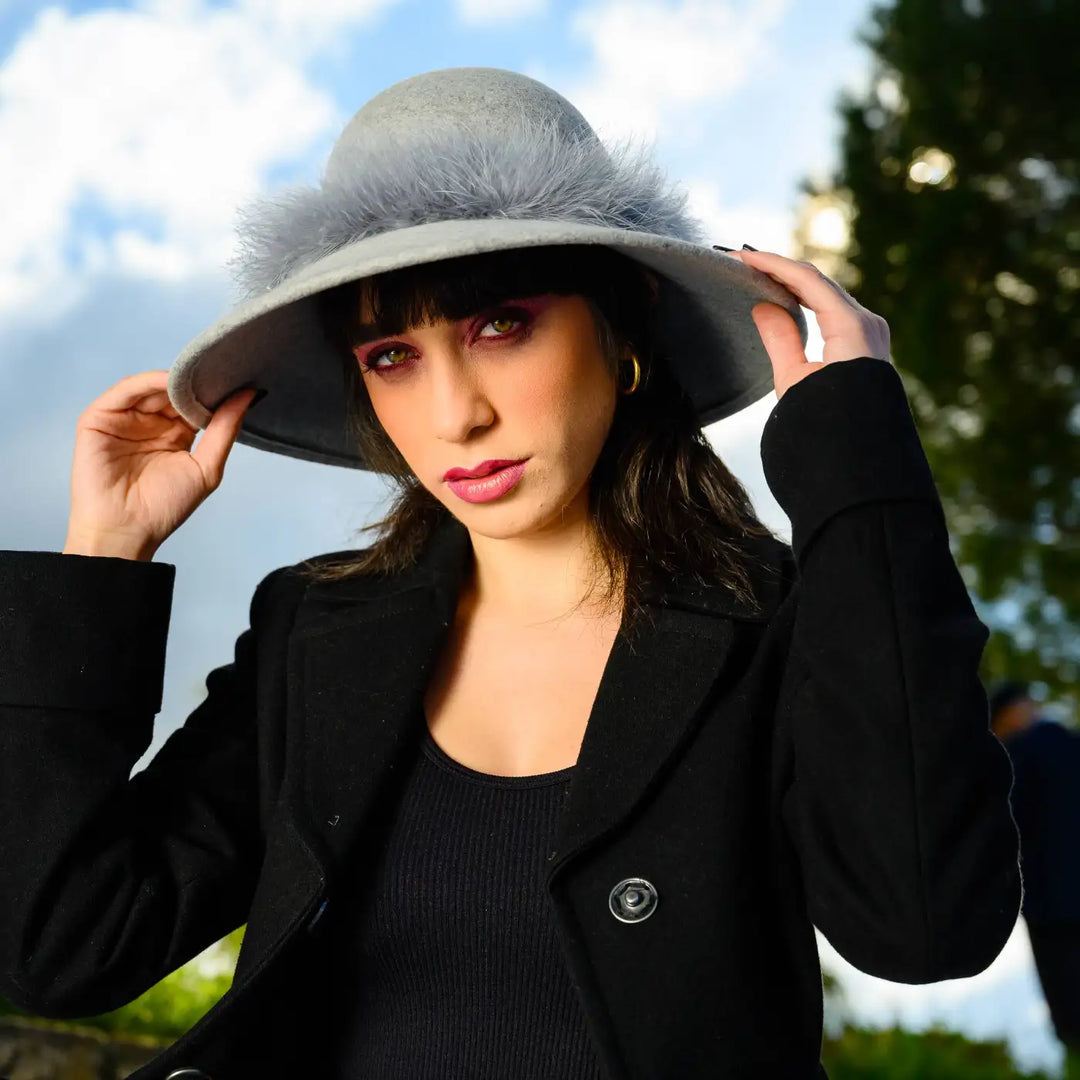 cappello a pamela in feltro di lana merinos con girotesta in marabou primario nesti grigio ritratto modella in giardino che tiene il cappello