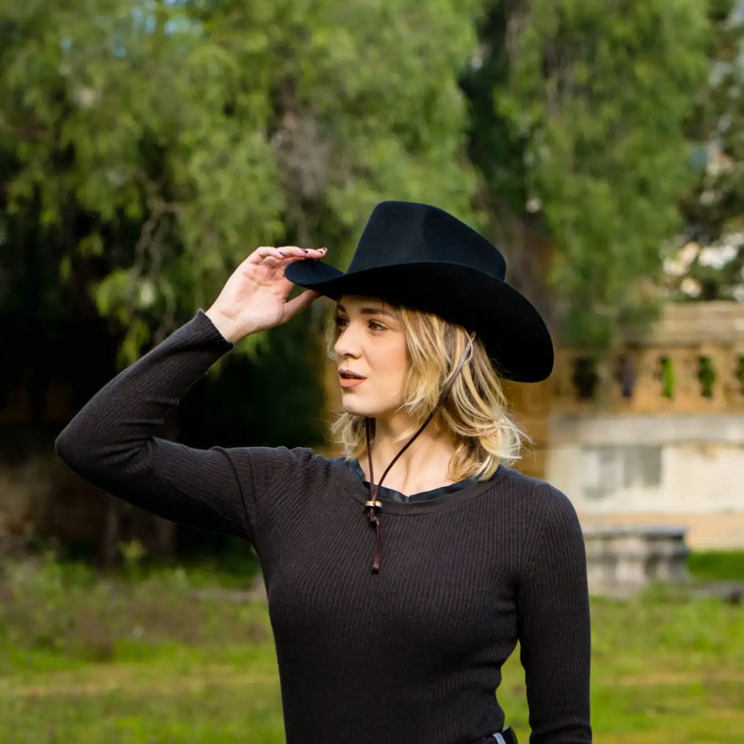 cappello da cowboy in feltro di lana merinos antipioggia primario nesti nero modella in total black in giardino storico reinterpretazione chic dello stile western