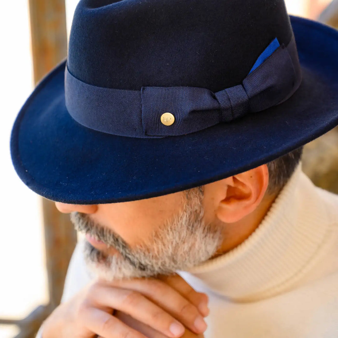 cappello fedora coccos in feltro di lana merinos primario nesti blu primo piano modello con barba curata studio della forma classica