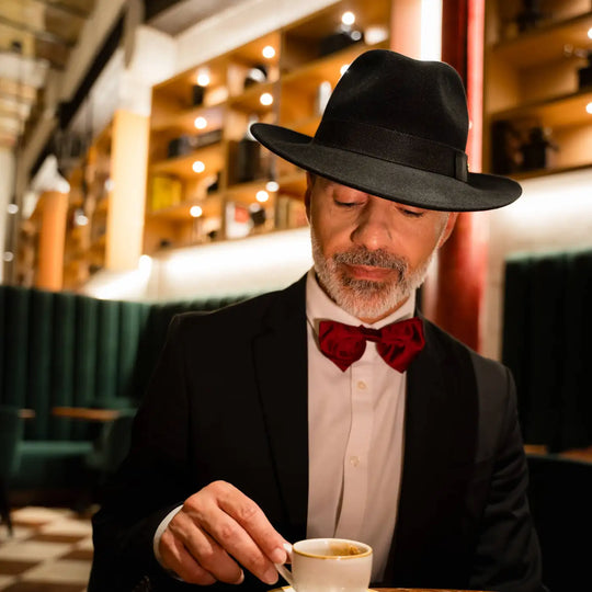 gentleman con cappello fedora primario nesti cashmere nero momento caffe elegante papillon bordeaux ambiente caffe storico palermo