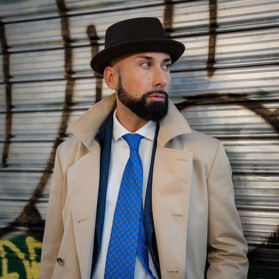 gentleman con pork pie primario nesti lapin marrone cravatta blu elettrico cappotto beige stile urban chic