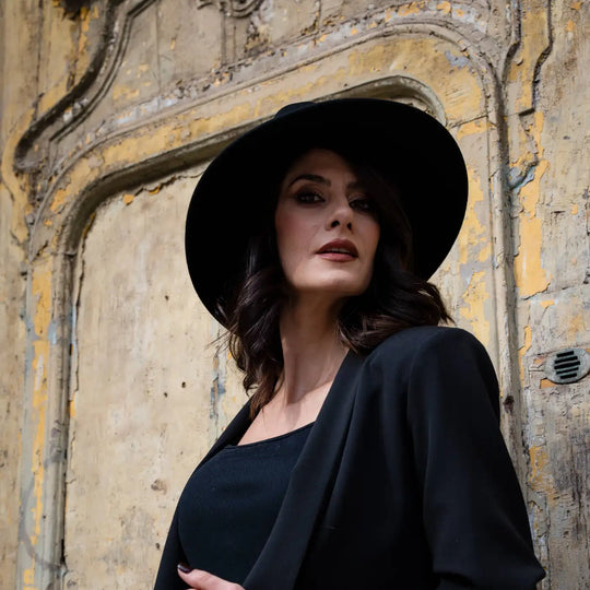 modella adulta con cappello signorile a tesa larga in feltro di lana merinos primario nesti nero e atmosfera dark chic