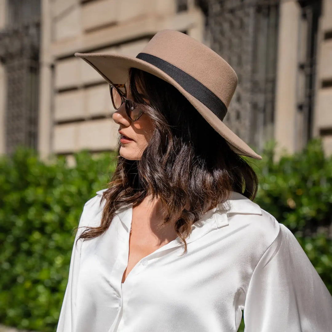 modella con cappello canotto primario nesti tesa larga piatta pose dinamica vegetazione urbana sfondo