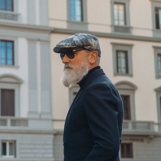 modello distinto con coppola peaky blinders di lana in fantasia chiara primario nesti street style urbano con palazzo storico fiorentino nel suo look casual elegante