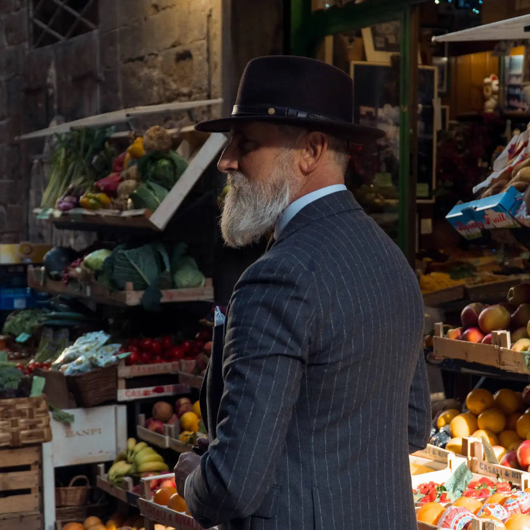 modello distinto in completo scuro con cappello fedora tradizionale primario nesti antipioggia cattura lessenza dello stile italiano al mercato locale di firenze