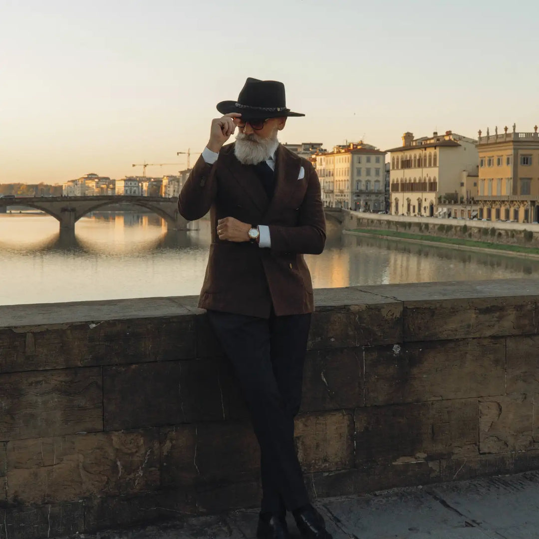 modello maturo elegante con cappello australiano primario nesti in lana merinos con sfondo cielo serale e architettura storica fiorentina