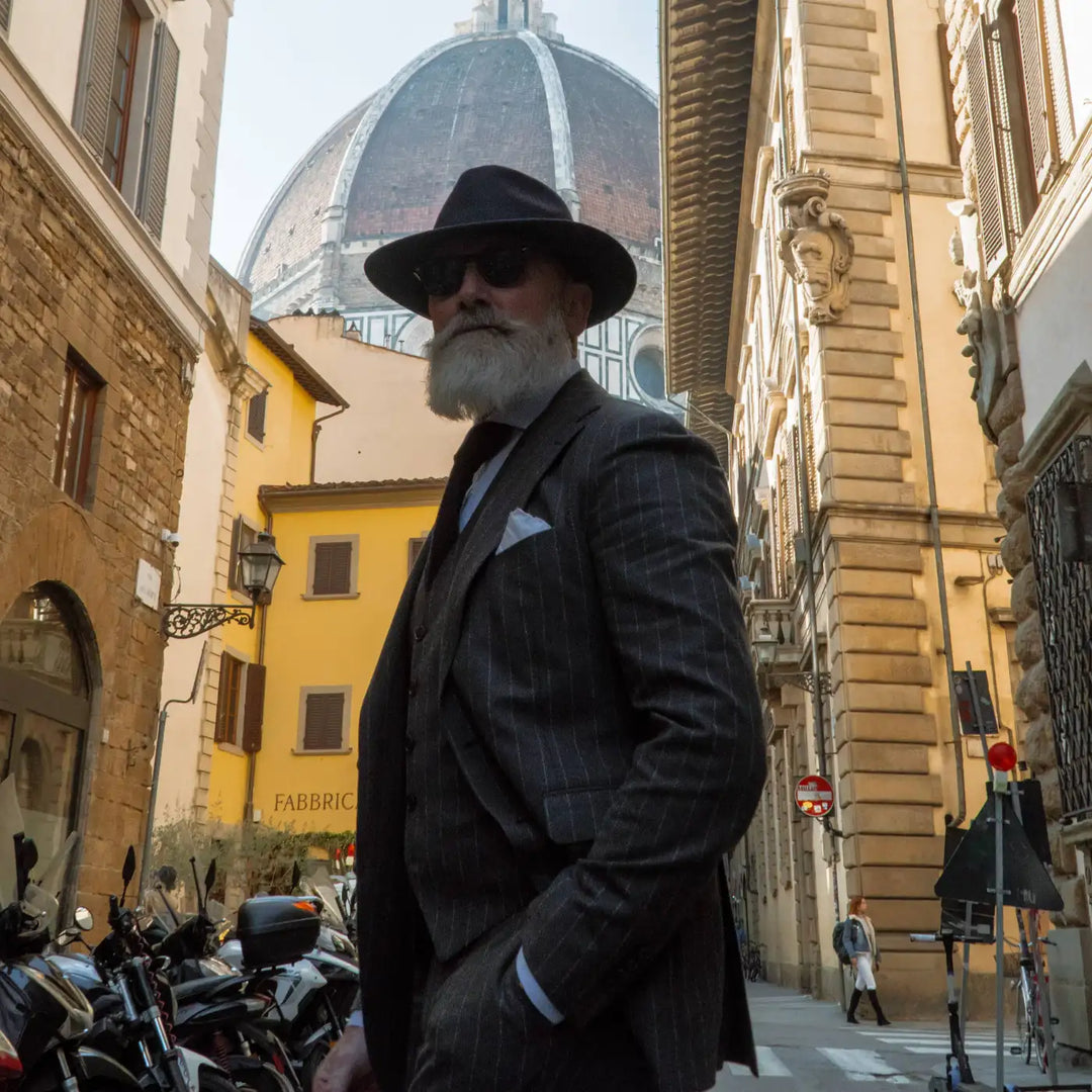 modello maturo elegante con cappello fedora coccos primario nesti in lana merinos colore marrone nel suo street style tra i vicoli di firenze