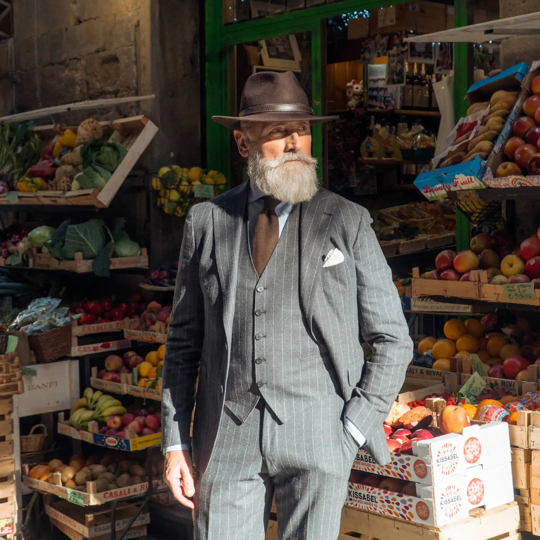 modello maturo indossa cappello fedora tradizionale primario nesti antipioggia colore marrone nella street style mercato