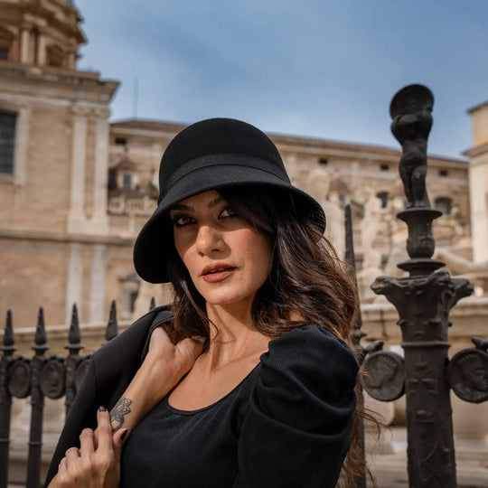 primo piano di modella adulta con cappello a cloche signorile a tesa media primario nesti e architettura siciliana storica