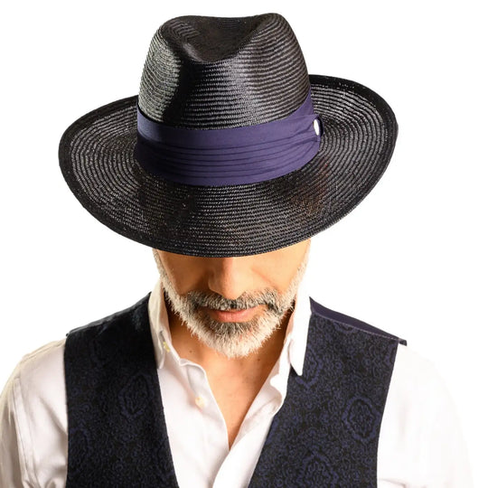primo piano frontale abbassato di uomo con barba che indossa un cappello fedora elegante in parasisol color blu realizzato da cappelleria primario nesti