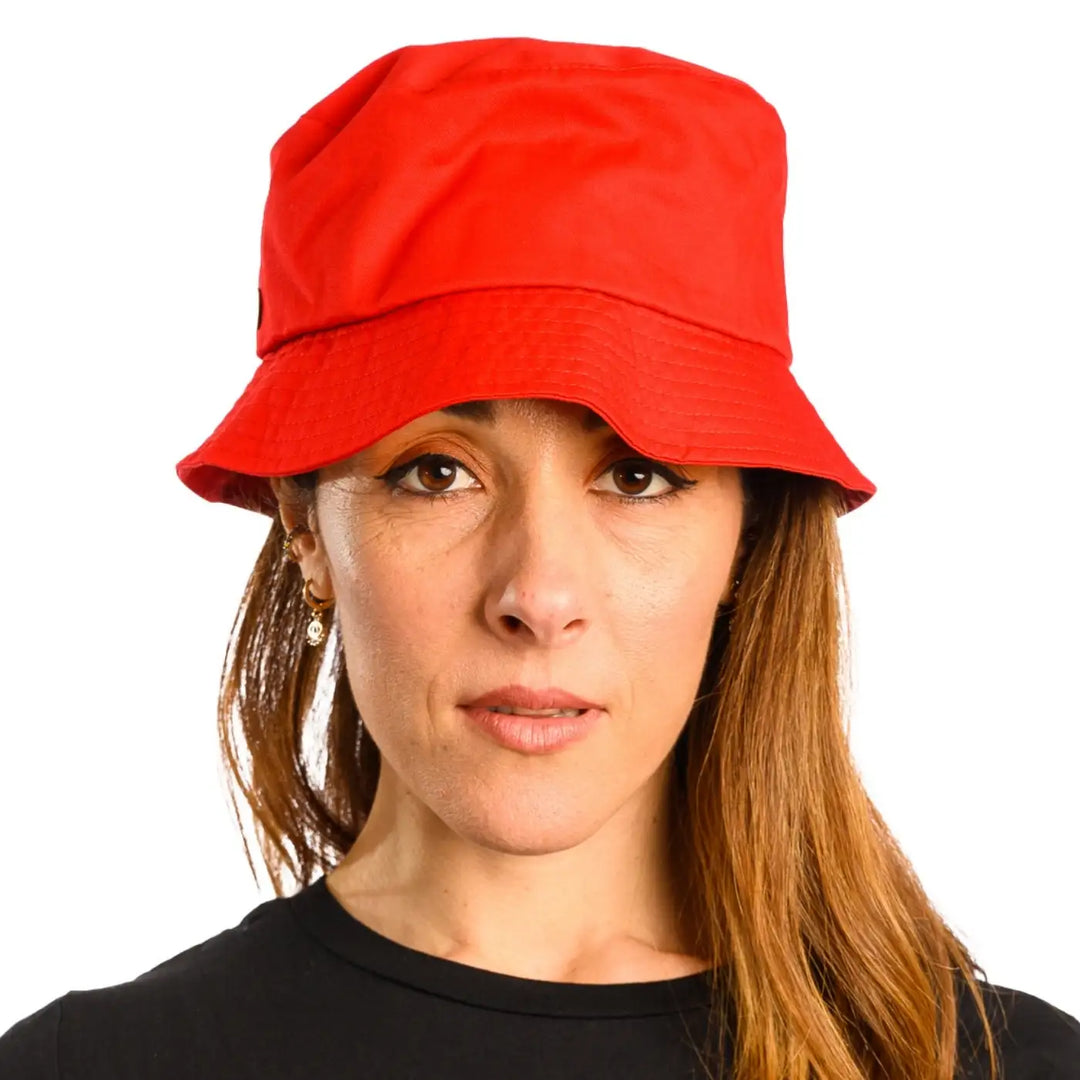 primo piano frontale di donna con capelli lunghi che indossa un cappello da pescatore sartoriale estivo color rosso realizzato da cappelleria primario nesti