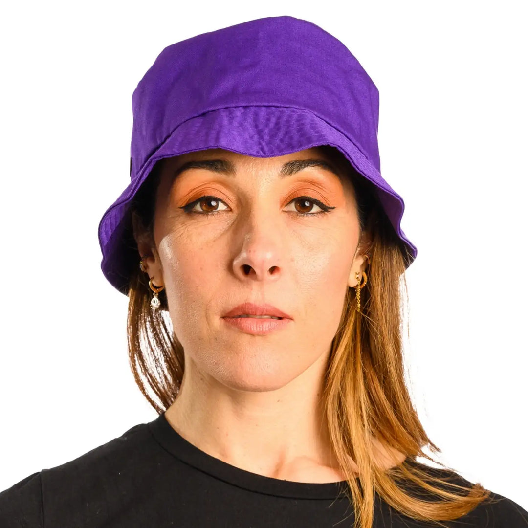 primo piano frontale di donna con capelli lunghi che indossa un cappello da pescatore sartoriale estivo color viola fatto da cappelleria primario nesti