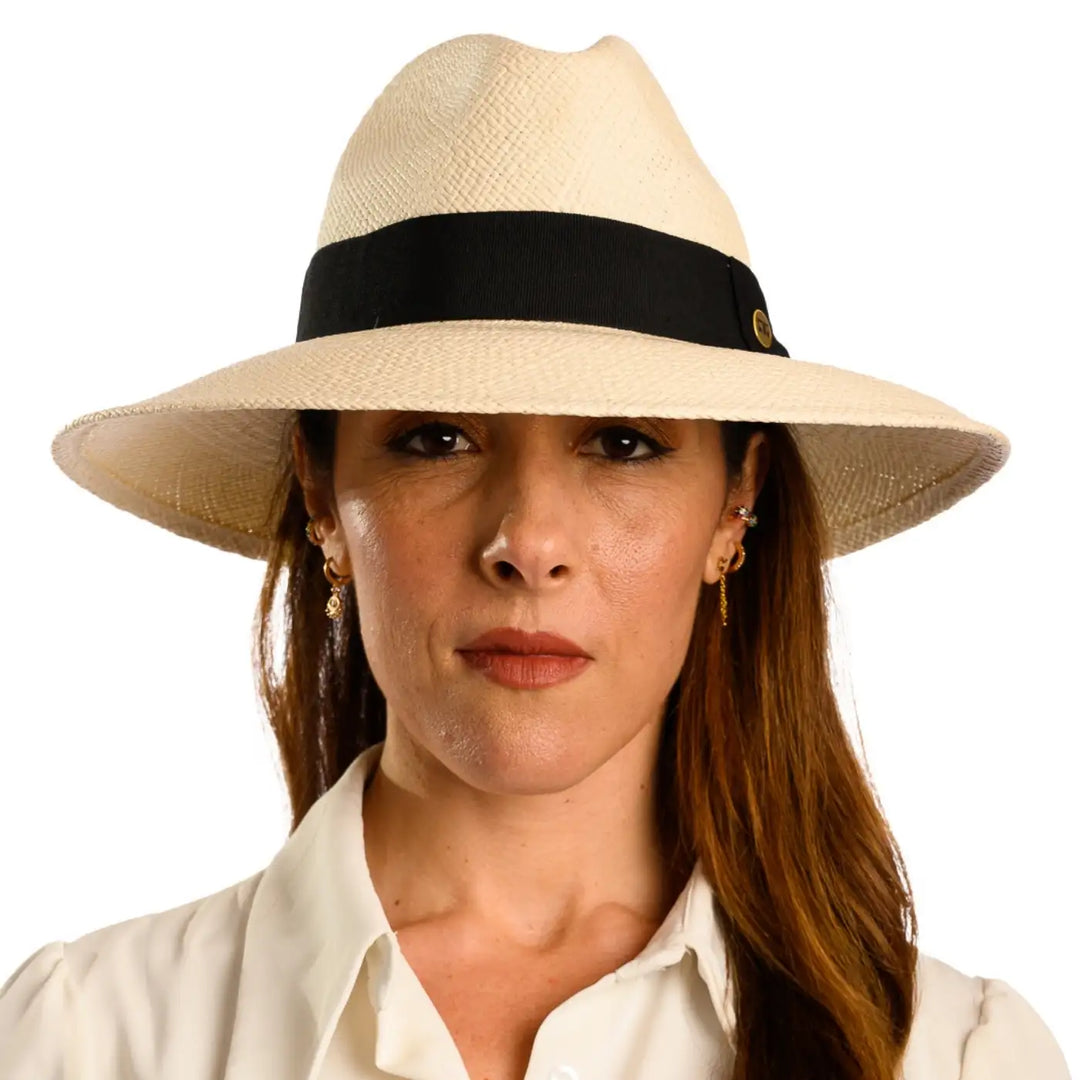 primo piano frontale di donna con capelli lunghi che indossa un cappello di panama a tesa larga da sole color bianco fatto da cappelleria primario nesti