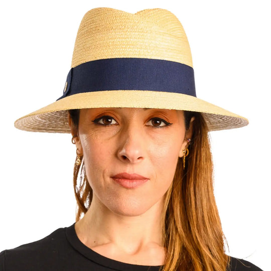 primo piano frontale di donna con capelli lunghi che indossa un cappello tesa larga in paglia di firenze color treccia chiara fatto da cappelleria primario nesti