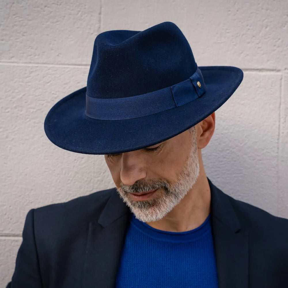 primo piano frontale di modello adulto elegante con cappello fedora in feltro di morbido cashmere blu primario nesti