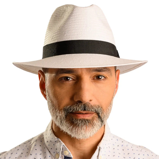 primo piano frontale di un signore adulto con barba che indossa un cappello da sole a tesa media estivo color bianco realizzato da cappelleria primario nesti