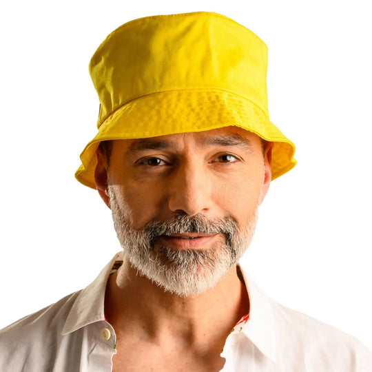 primo piano frontale di uomo con barba che indossa un cappello da pescatore sartoriale estivo color giallo fatto da cappelleria primario nesti