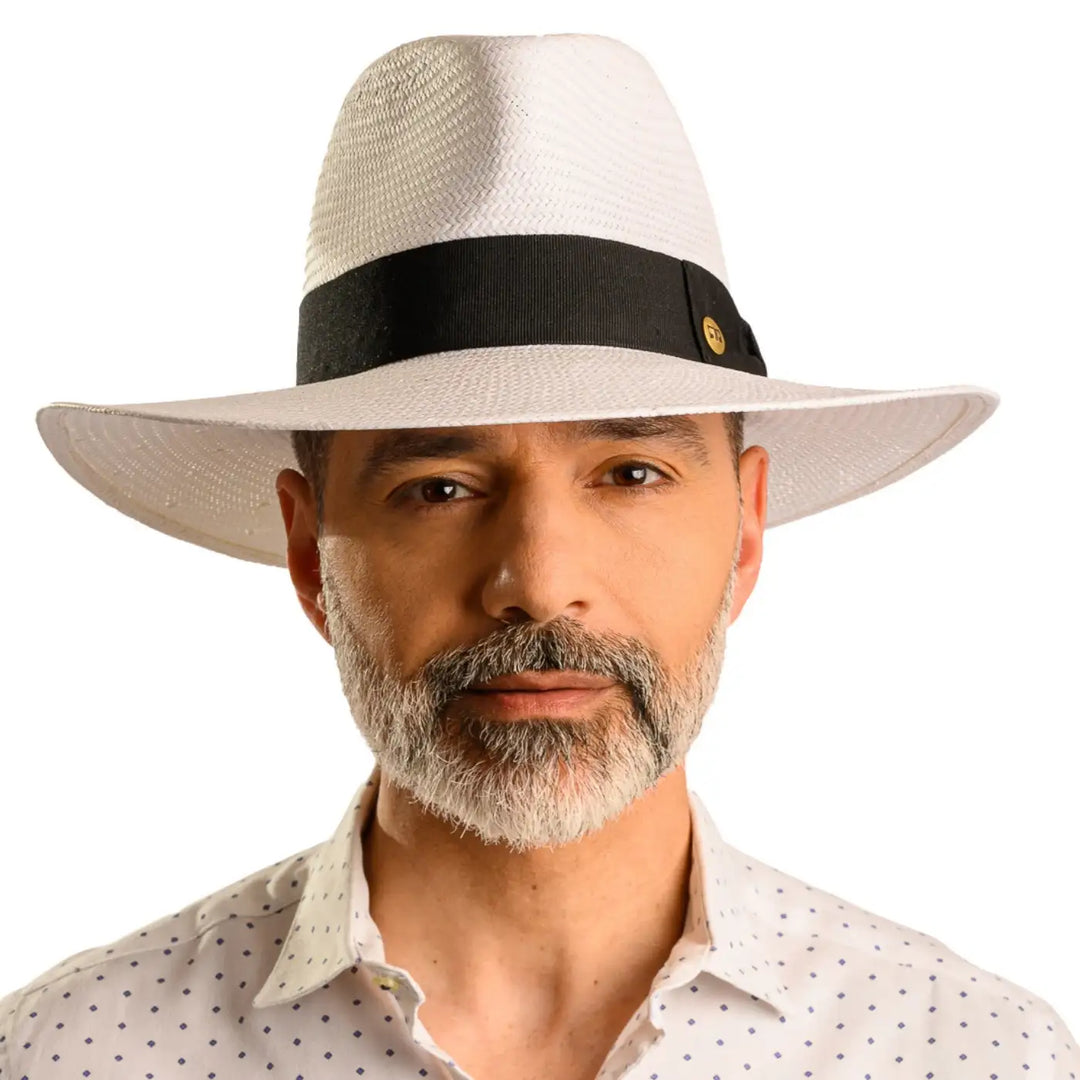 primo piano frontale di uomo con barba che indossa un cappello da sole a tesa larga estivo color bianco fatto da cappelleria primario nesti