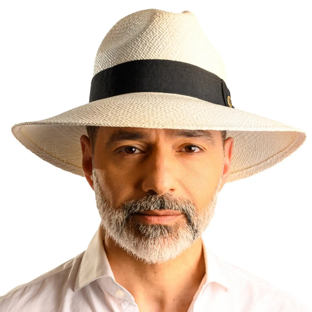 primo piano frontale di uomo con barba che indossa un cappello di panama a tesa larga da sole color bianco fatto da cappelleria primario nesti