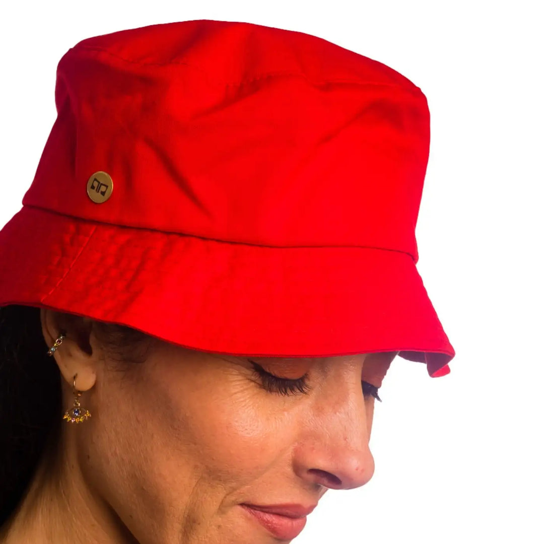 primo piano frontale inclinato di donna con capelli lunghi che indossa un cappello da pescatore sartoriale estivo color rosso fatto da cappelleria primario nesti