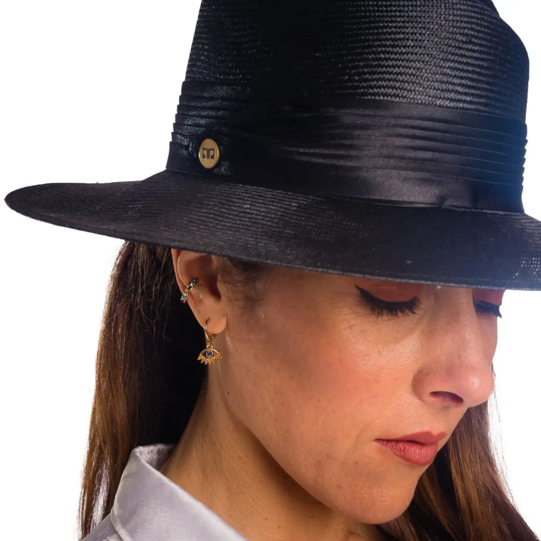 primo piano frontale ravvinato di donna con capelli lunghi che indossa un cappello tesa larga elegante in parasisol color nero fatto da primario nesti