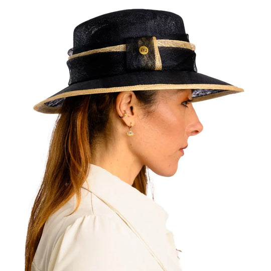primo piano laterale di donna adulta con capelli lunghi che indossa un cappello da cerimonia estivo elegante color blu camel realizzato da primario nesti