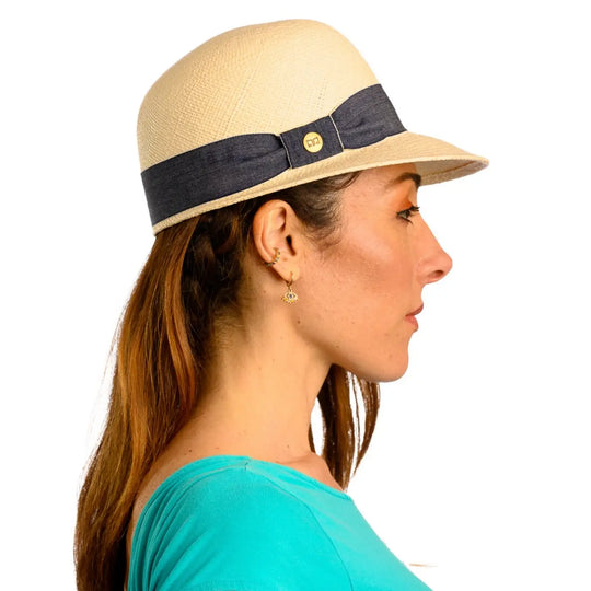 primo piano laterale di donna adulta con capelli lunghi che indossa un cappello di panama con visiera corta color bianco realizzato da cappelleria primario nesti