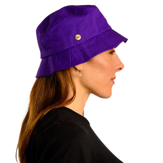 primo piano laterale di donna con capelli lunghi che indossa un cappello da pescatore sartoriale estivo color viola realizzato da cappelleria primario nesti