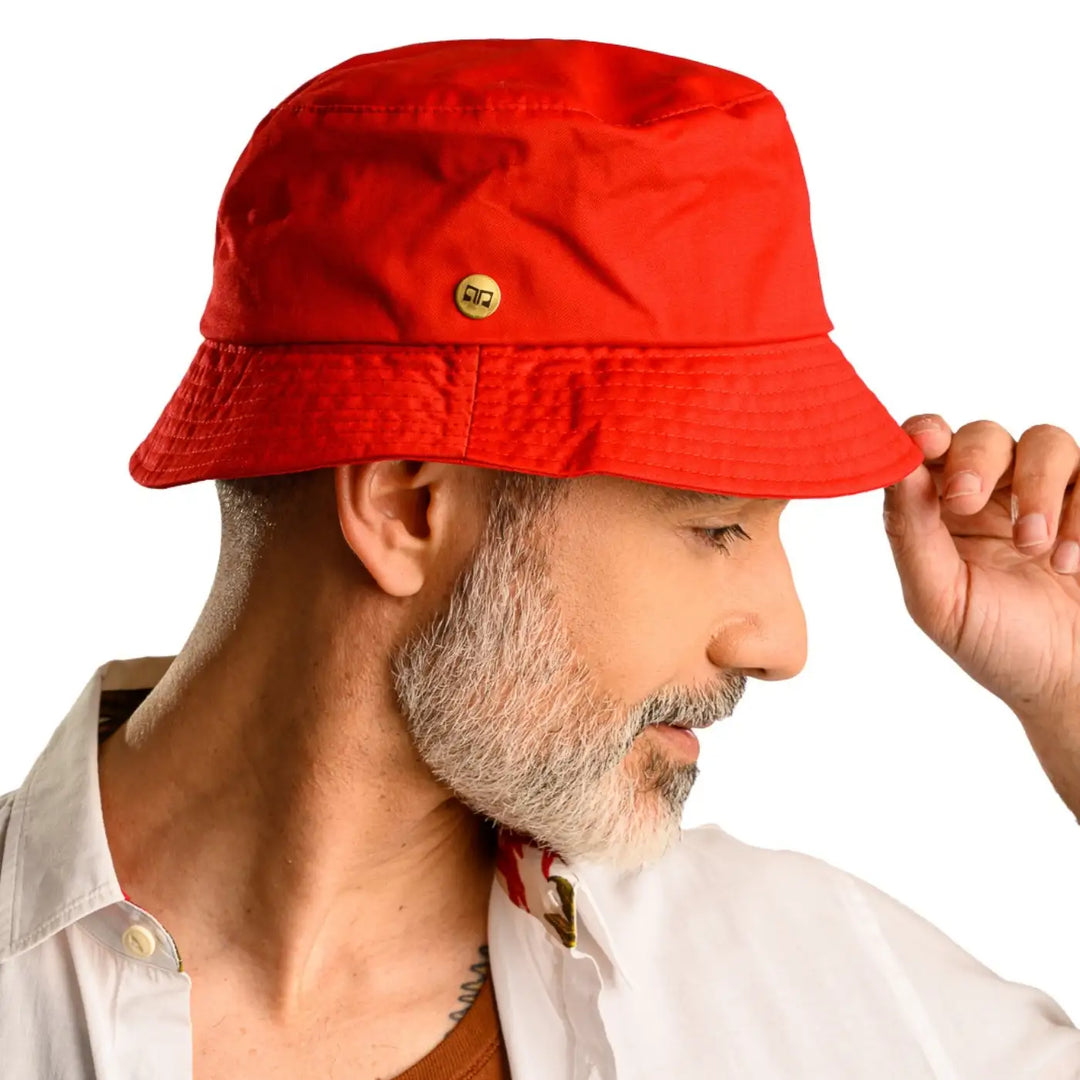 primo piano laterale di uomo con barba che indossa un cappello da pescatore sartoriale estivo color rosso realizzato da cappelleria primario nesti