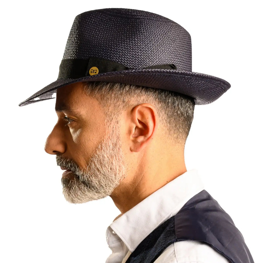 primo piano laterale di uomo con barba che indossa un cappello di panama in stile fedora color blu fatto da cappelleria primario nesti