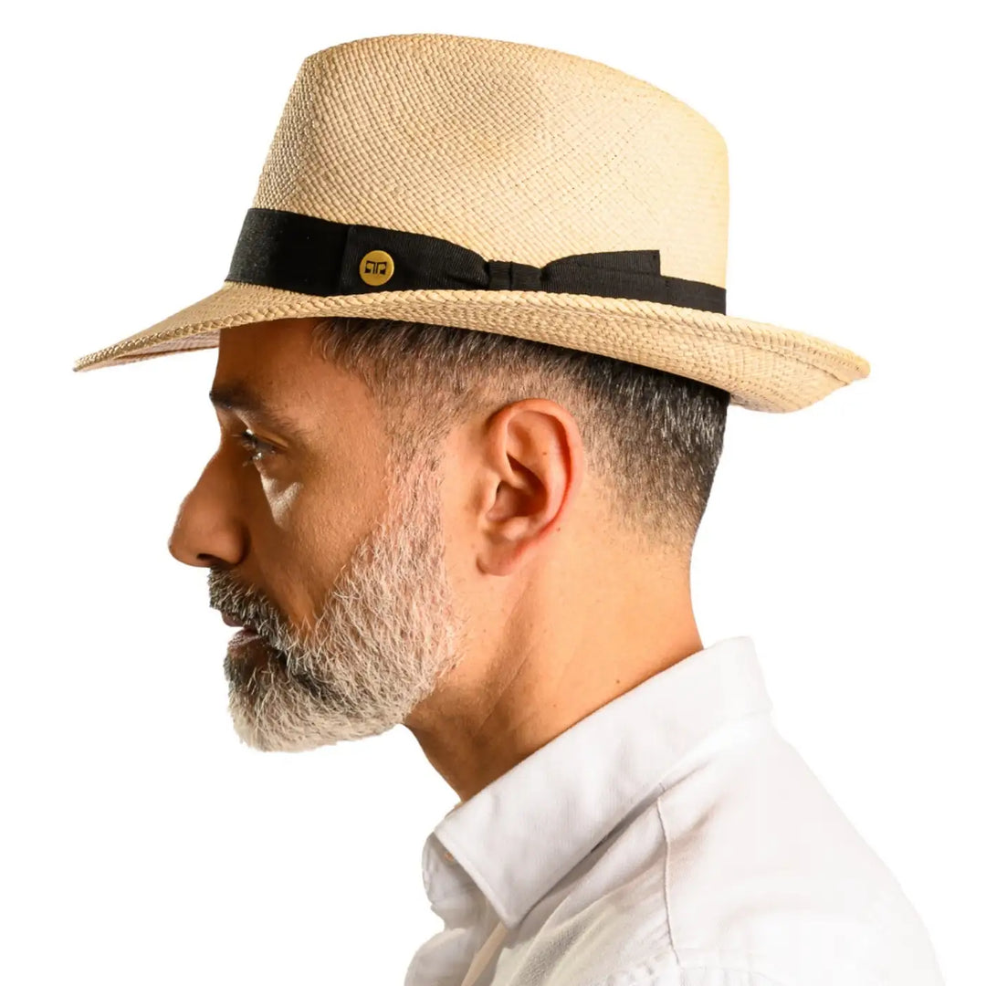 primo piano laterale di uomo con barba che indossa un cappello di panama in stile fedora color naturale fatto da cappelleria primario nesti