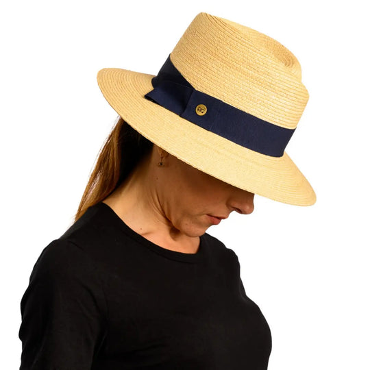primo piano laterale inclinato di donna con capelli lunghi che indossa un cappello tesa larga in paglia di firenze color treccia chiara realizzato da primario nesti