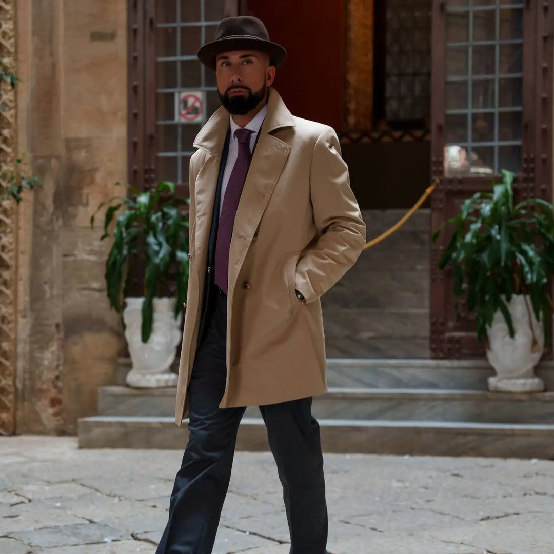 uomo elegante con cappello lobbia homburg primario nesti lapin look urban con cappotto cammello pavimentazione storica