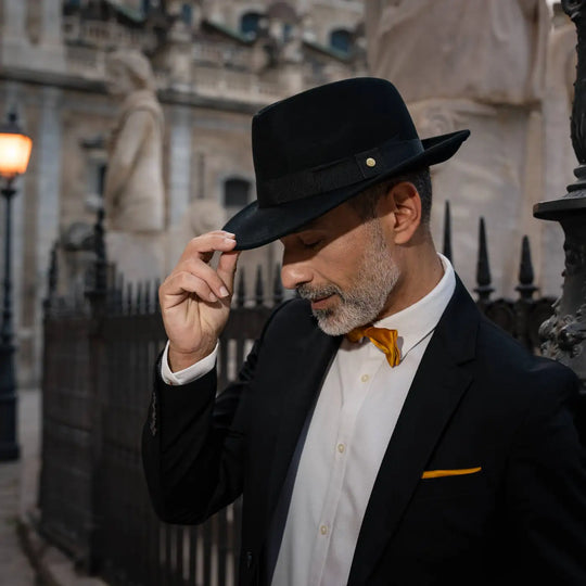 uomo maturo con cappello fedora primario nesti cashmere nero ambientazione serale lampioni storici centro palermo