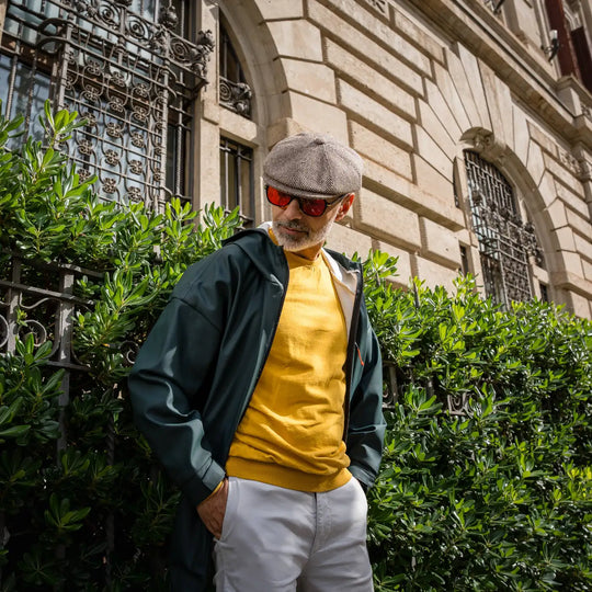 uomo maturo con coppola peaky blinders primario nesti invernale maglione giallo acceso barba silver