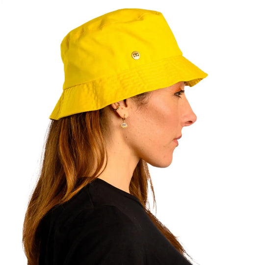 vista laterale di donna con capelli lunghi che indossa un cappello da pescatore sartoriale estivo color giallo fatto a mano da cappelleria primario nesti