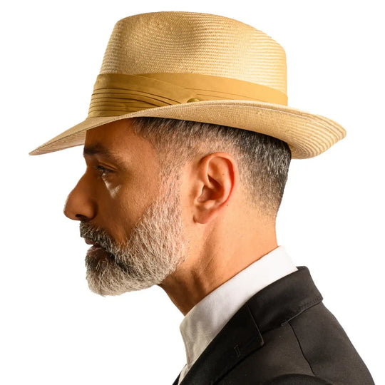 vista laterale di un uomo con barba che indossa un cappello fedora elegante in parasisol color camel fatto a mano da cappelleria primario nesti