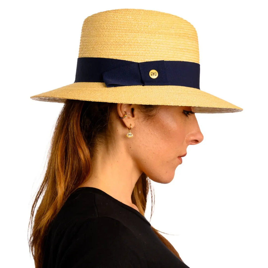 vista laterale di una donna con capelli lunghi che indossa un cappello tesa larga in paglia di firenze color treccia chiara fatto a mano da primario nesti