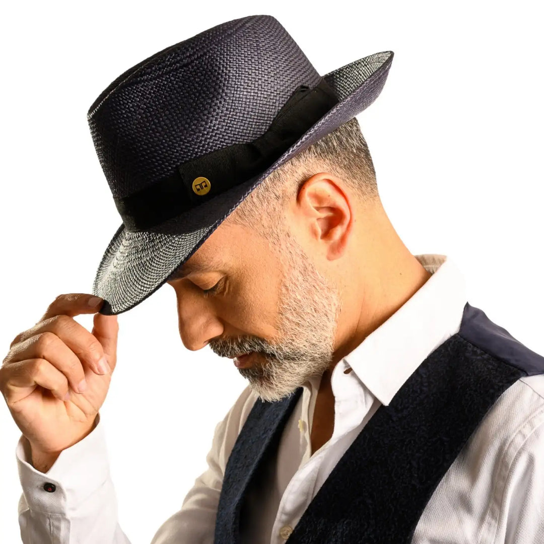 vista laterale inclinata di un uomo con barba che indossa un cappello di panama in stile fedora color blu fatto a mano da cappelleria primario nesti
