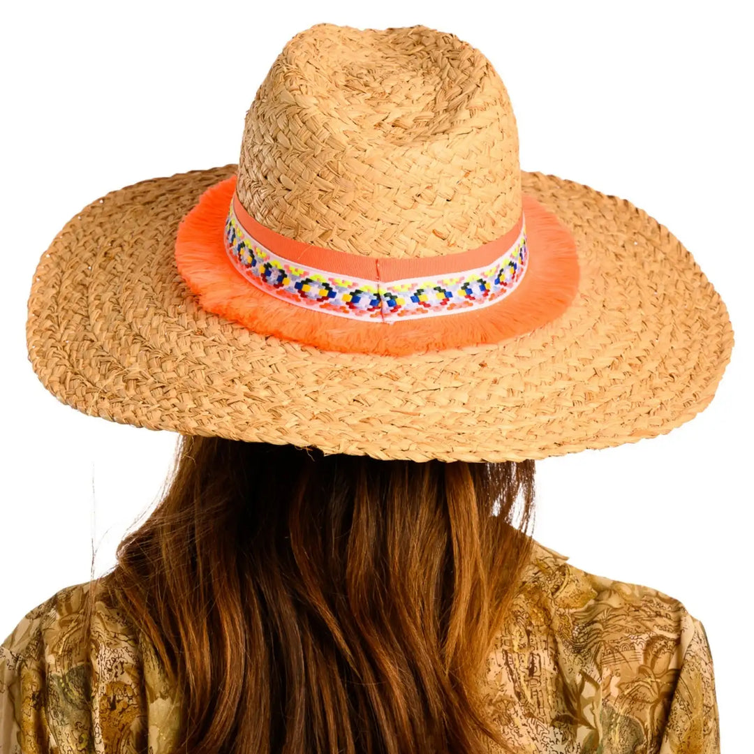 vista posteriore di una donna con capelli lunghi che indossa un cappello da mare a tesa larga in rafia color paglia arancio fatto a mano da cappelleria primario nesti