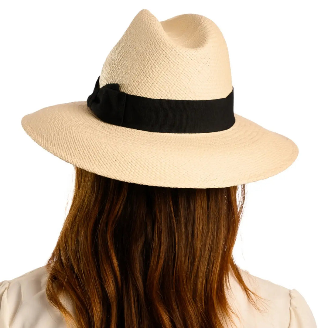 vista posteriore di una donna con capelli lunghi che indossa un cappello di panama a tesa larga da sole color bianco fatto a mano da cappelleria primario nesti