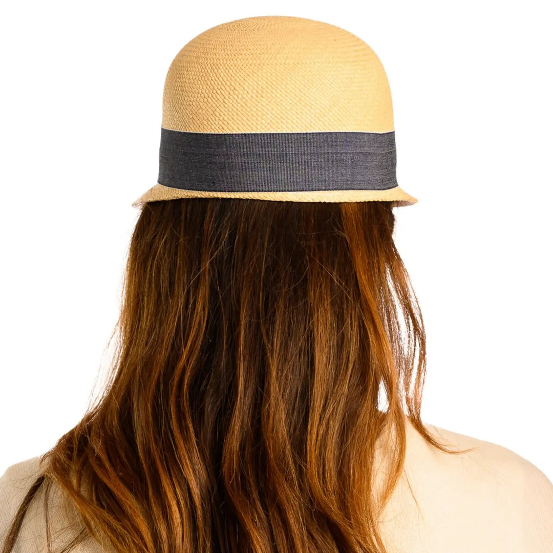 vista posteriore di una donna con capelli lunghi che indossa un cappello di panama con visiera corta color naturale fatto a mano da cappelleria primario nesti